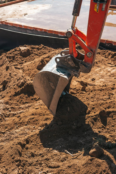 Graafmachine schep graven op vuil op een bouwplaats - Foto, afbeelding