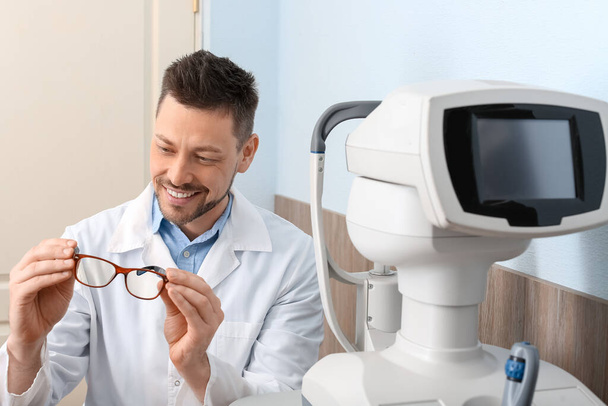 Oftalmólogo masculino con anteojos en clínica - Foto, imagen