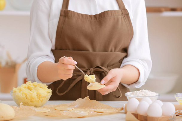 Woman preparing tasty dumplings on kitchen table, closeup - Photo, Image