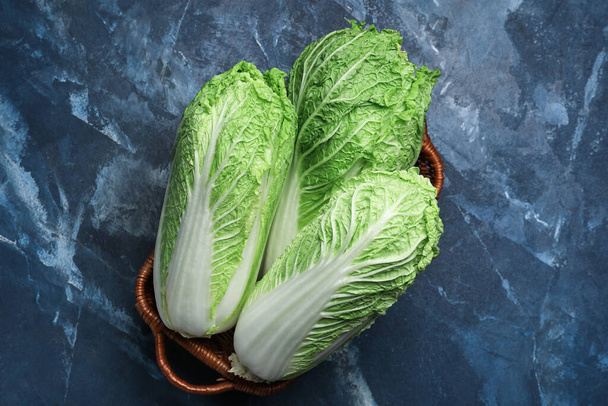 Basket with fresh chinese cabbage on color background - Photo, Image