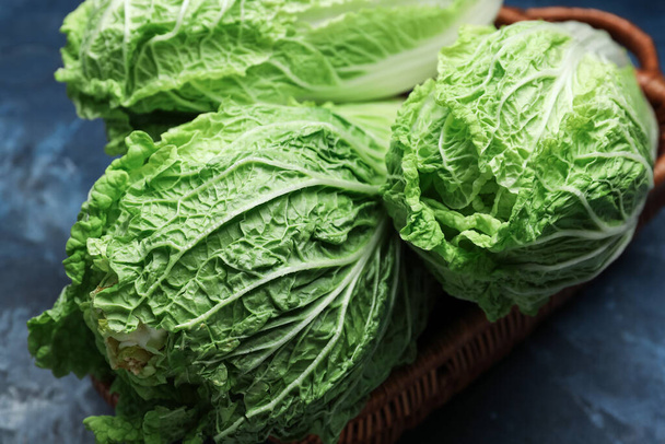 Basket with fresh chinese cabbage on color background, closeup - Photo, Image