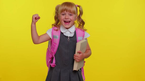 Felice ragazzina adolescente in uniforme scolastica celebrare il successo vincere facendo gesto vincitore dire Sì - Foto, immagini