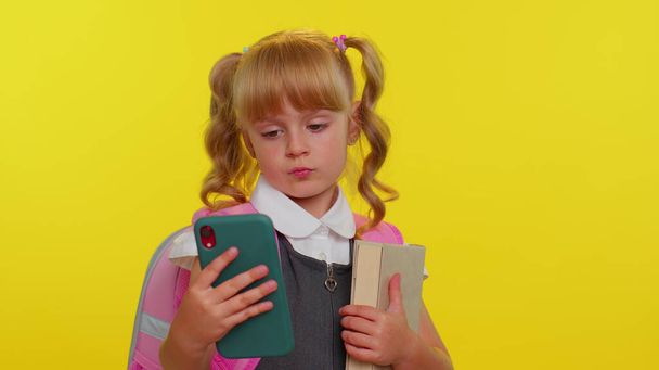学校の制服の女の子の子供は、新しい投稿を入力携帯電話を使用して, smsメッセージ,ソーシャルネットワークの閲覧 - 写真・画像