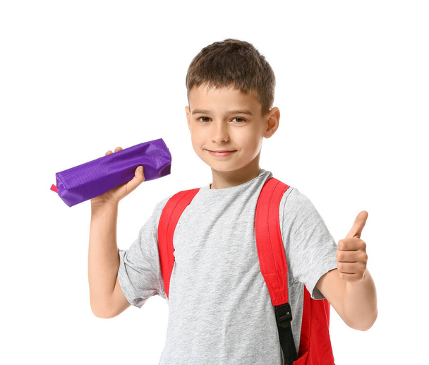 Little schoolboy with pencil case showing thumb-up on white background - Zdjęcie, obraz