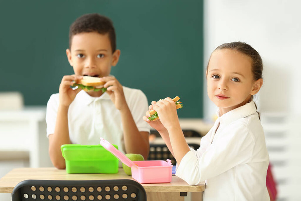 Niedliche kleine Kinder beim Mittagessen in der Schule - Foto, Bild