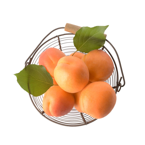 Korb mit leckeren reifen Aprikosen auf weißem Hintergrund - Foto, Bild