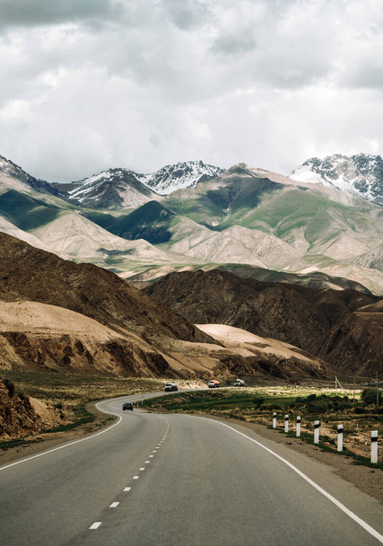A vertical shot of a winding, long road passing through the mountains - Φωτογραφία, εικόνα