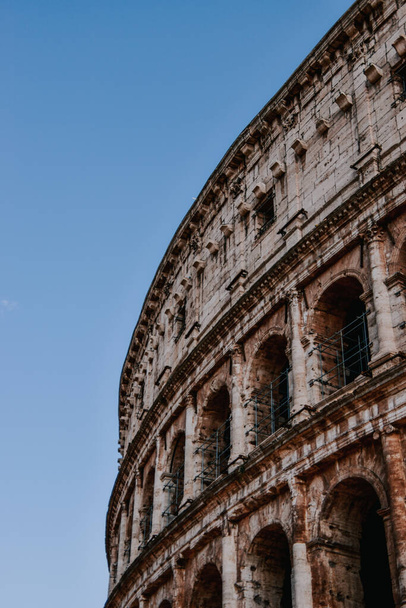 A low angle sh of the Colosseum in Rome, Italy against a clear blue sky - Photo, image