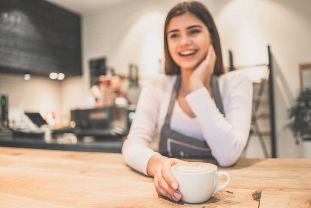 A boldog pincérnő kezében egy csésze kávé egy kávézóban - Fotó, kép