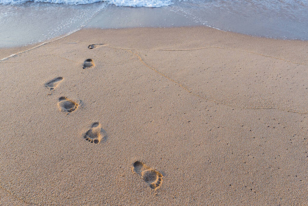 αποτύπωμα ποδιού στην άμμο στο φόντο της παραλίας - Φωτογραφία, εικόνα