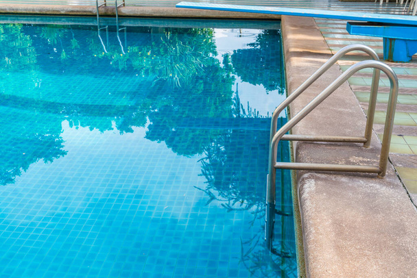 Лестница для захвата баров на фоне голубого бассейна - Фото, изображение