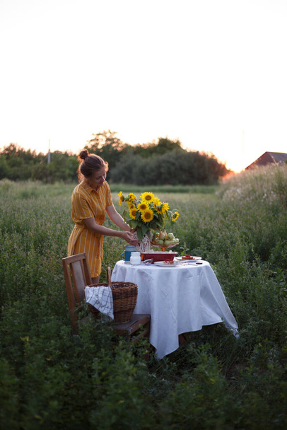 garden and still life. tea party in the garden - girl and bouquet with sunflowers on the tabl - Foto, Imagem