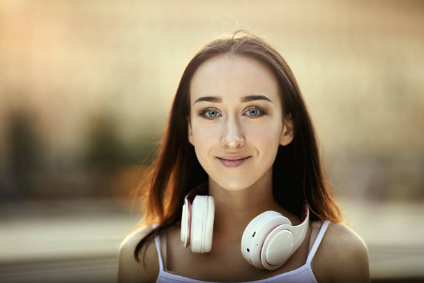 White woman with cordless headphones at daytime. - Zdjęcie, obraz