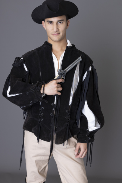 Um personagem pirata segurando uma arma contra um pano de fundo cinza - Foto, Imagem