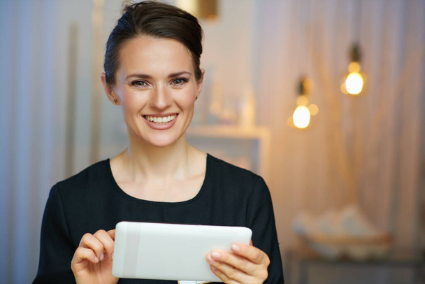 smiling middle aged woman employee with tablet PC in modern beauty salon. - Foto, Bild