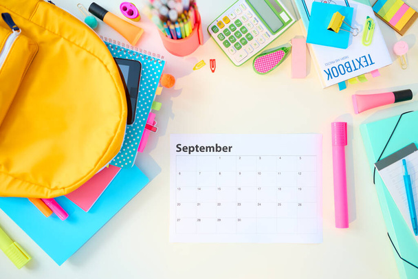 Back to school. Upper view of white desk with workbooks, stationary, textbook, september calendar and backpack at school child room in sunny day. - Fotoğraf, Görsel