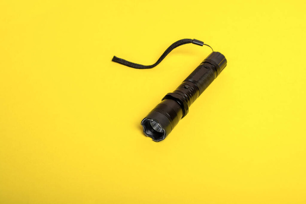 schwarze Taschenlampe Schocker auf gelbem Hintergrund - Foto, Bild