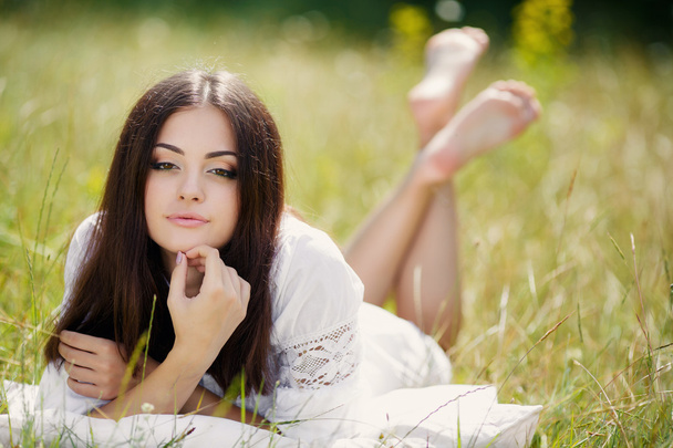The girl with a pillow on the fresh spring grass. - Φωτογραφία, εικόνα