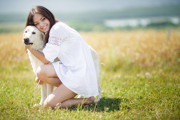 Beautiful woman plays with the dog on the Meadow - Fotó, kép