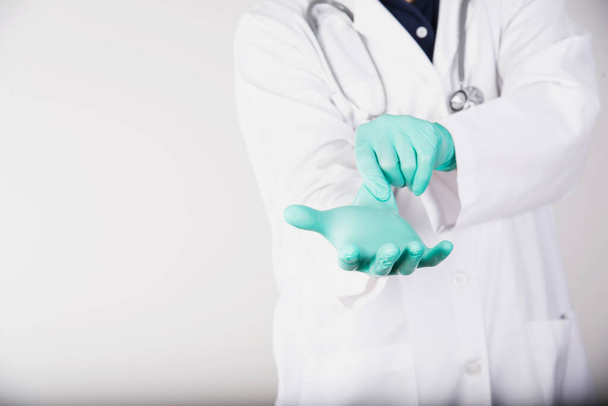 Doctor is putting green surgery glove for self protection in medical operation process - health care during Covid-19 spreading period - Fotografie, Obrázek