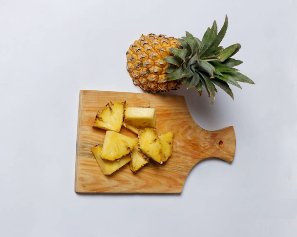 Hele ananas geïsoleerd op een heldere achtergrond. Close-up zicht op verse en heerlijke ananas. Overrijpe ananassen die beginnen te rotten zullen een zoete, honingachtige vloeistof vrijgeven. Focus wazig. Mockup van ananas. - Foto, afbeelding