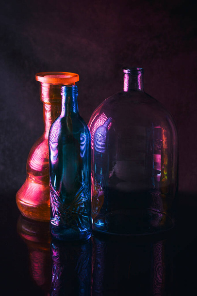 Натюрморт зі скляним посудом з відображенням на темному фоні
 - Фото, зображення