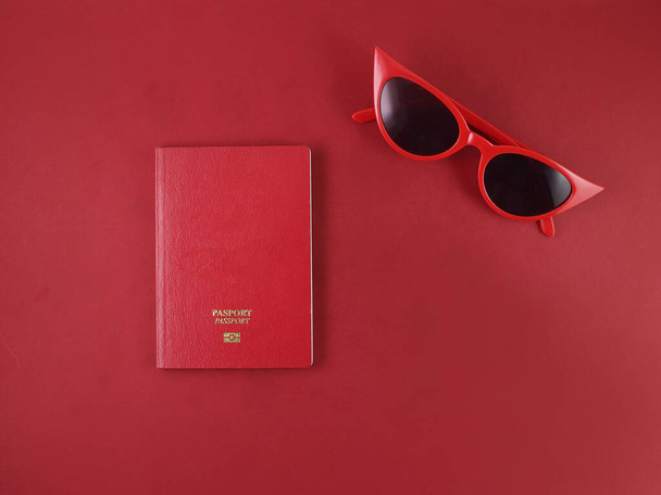 Red eyewear sunglass passport book travel vacation red paper background - Foto, immagini