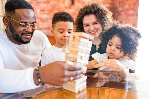 african mixed race family palying a round of jenga in cozy living room - Foto, Imagem