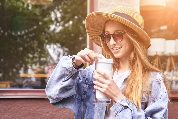 Pretty girl drink beverage outdoors. Buy takeaway coffee in own cup. Real people - Zdjęcie, obraz