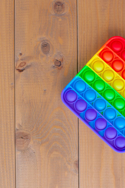 Draufsicht auf das neue sensorische Spielzeug-Rainbow pop it. Anti-Stress-Spielzeug für Kinder und Erwachsene. Ein buntes Spielzeug - Foto, Bild