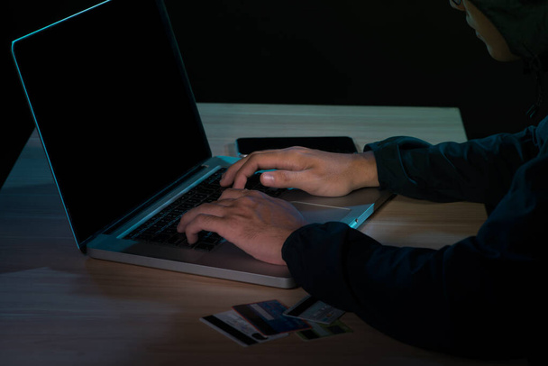 Homme travaillant sur un ordinateur portable dans une pièce sombre
 - Photo, image
