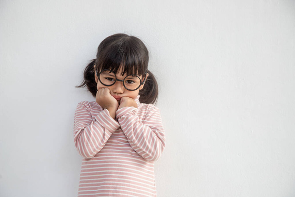 vicces ázsiai gyermek lány visel szemüveg egy fehér háttér - Fotó, kép