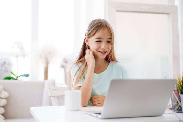Boldog kislány tanuló használja laptop otthon - Fotó, kép