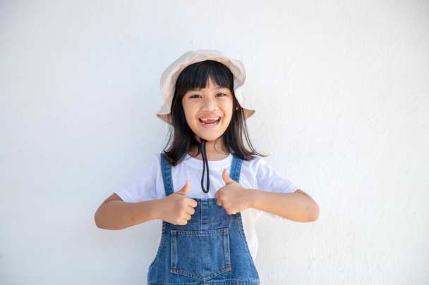 ázsiai gyerek mutassa hüvelykujját, hogy felviduljon boldogan - Fotó, kép