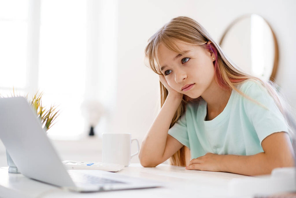 Happy little girl pupil using laptop at home - Φωτογραφία, εικόνα