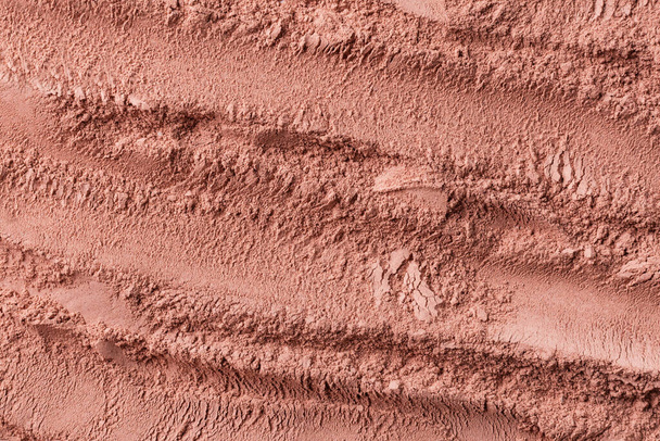 Текстура сухой красной косметической глины с видом сверху. Абстрактный фон розовой косметической глины или тени для глаз. - Фото, изображение