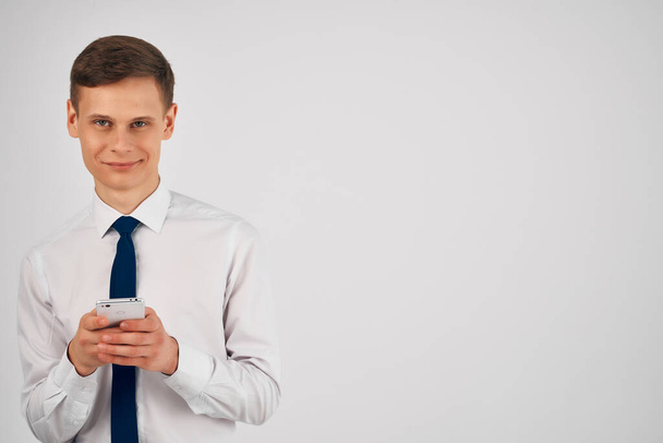επιχειρηματίας σε πουκάμισο με γραβάτα κρατώντας το τηλέφωνο στα χέρια  - Φωτογραφία, εικόνα
