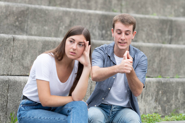 Young couple sitting on stairs quarreling. Bad and toxic relationships concept - Photo, Image