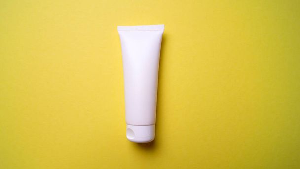 Embalaje de crema para manos o cara sobre fondo amarillo - Foto, Imagen