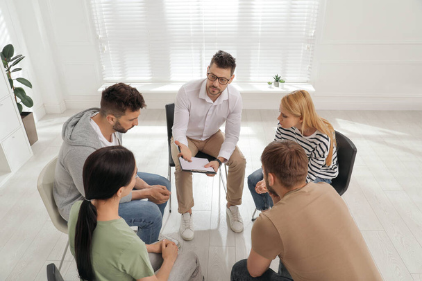 Psychotherapist working with group of drug addicted people at therapy session indoors - Foto, Imagem