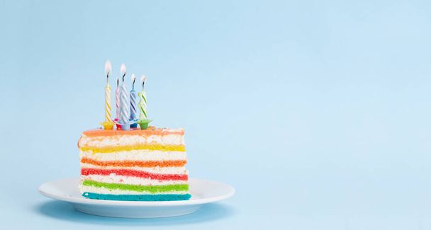 誕生日や休日のケーキあなたの挨拶のためのコピースペースと青の背景に燃えるろうそく - 写真・画像