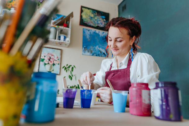 Női művész öntő akril közeg festéséhez kép folyadék öntési technika - Fotó, kép