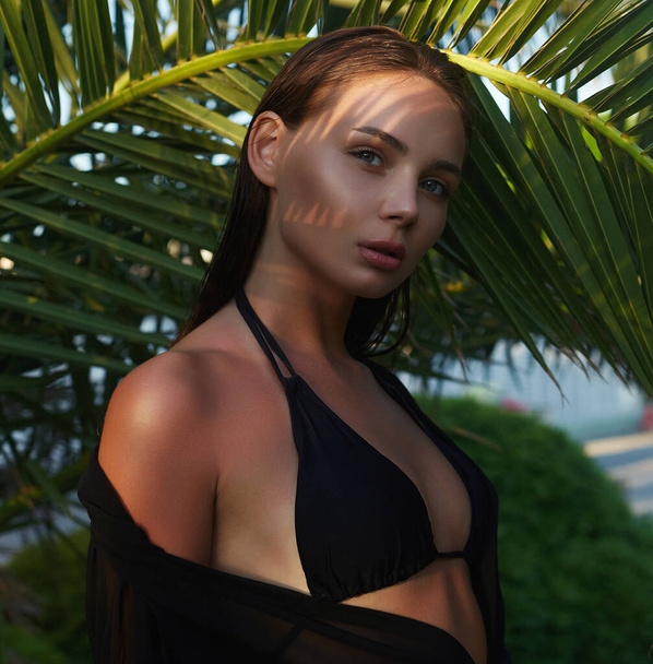 Gün batımında güzel bir yaz kızı. Palmiye ağacının altında bikinili seksi bir kadın. Güzellik Portresi - Fotoğraf, Görsel