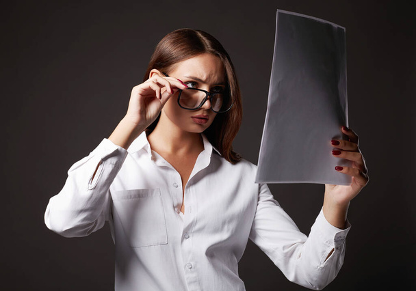 όμορφη νεαρή γυναίκα με γυαλιά κοιτάζοντας τα έγγραφα. πορτρέτο της κυρίας των επιχειρήσεων - Φωτογραφία, εικόνα