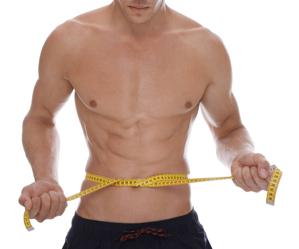 Shirtless man with slim body and measuring tape around his waist isolated on white, closeup - Foto, immagini