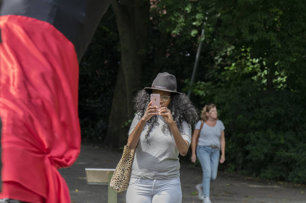 Donna che scatta foto al monumento nazionale alla schiavitù al festival Keti Koti ad Amsterdam Paesi Bassi 2-7-2020 - Foto, immagini