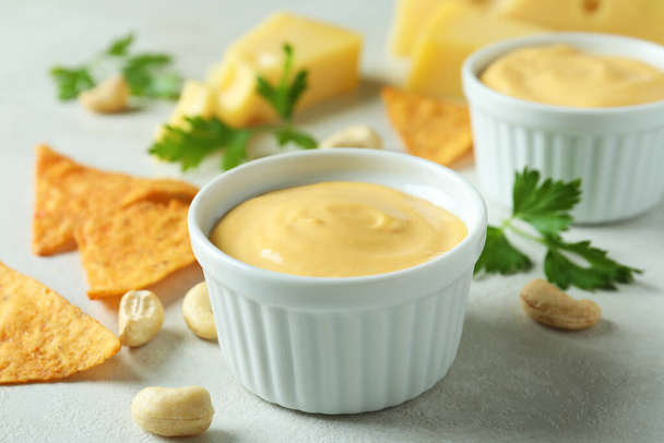 Salsa di formaggio e snack su tavola bianca testurizzata - Foto, immagini