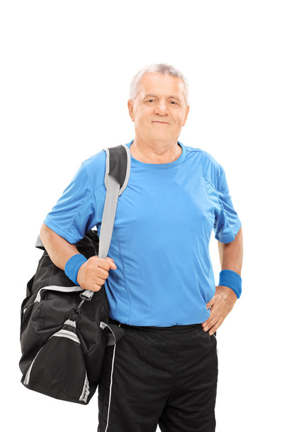 Mature man holding sports bag - Foto, afbeelding