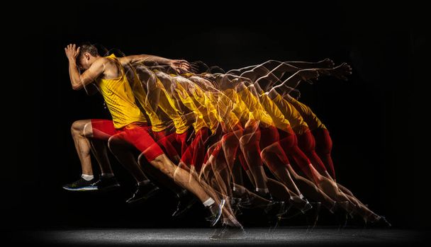 Portrait of young man, professional male athlete, runner in motion and action isolated on dark background. Stroboscope effect. - Fotografie, Obrázek