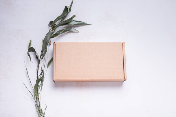 Brown flat cardboard carton box decorated with dried leaves, top - Φωτογραφία, εικόνα